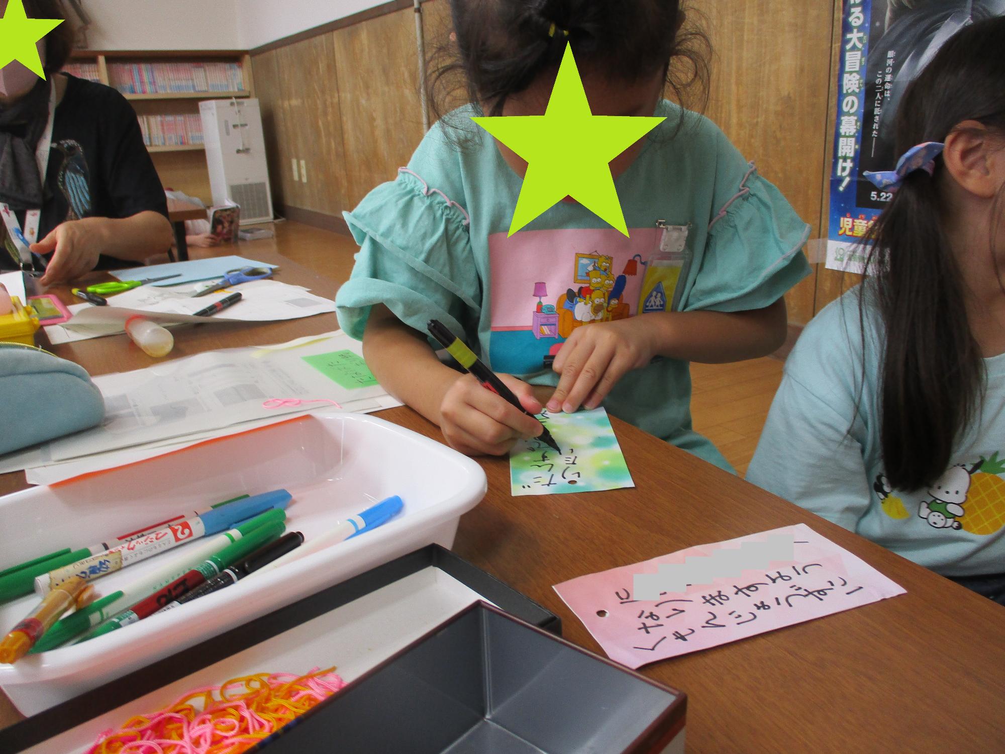 短冊に願い事を書いている子