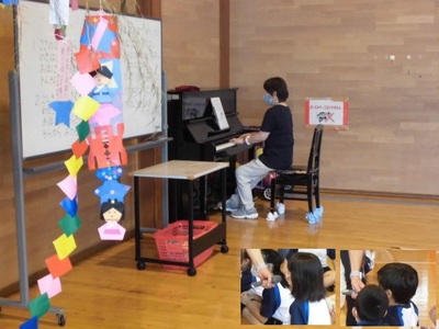 先生がピアノを弾いていて、それを子どもたちが聴いている様子。