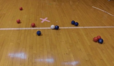 赤や青のボールが散らばり、中央に白いボールがある状態の写真