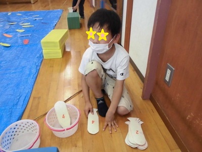 男の子が釣った魚の紙の裏に書かれた点数を確認している写真