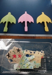 壁面の飾りとなる傘の形をした紙や星の紙の写真