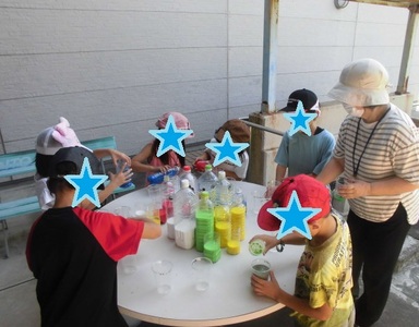 児童らが色水を容器に混ぜて色の変化を楽しんでいる様子の写真