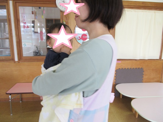 0歳児は保育士の抱っこで安心している様子