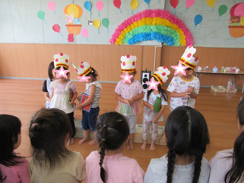 お誕生児がお友達から、お歌のプレゼントを受けている様子です。