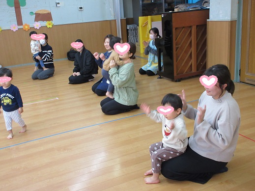 親子で手遊びを楽しむ1歳児