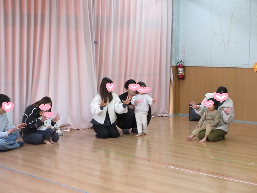 親子で手遊びを楽しむ1歳児