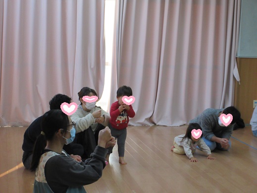 親子で手遊びを楽しむ1歳児