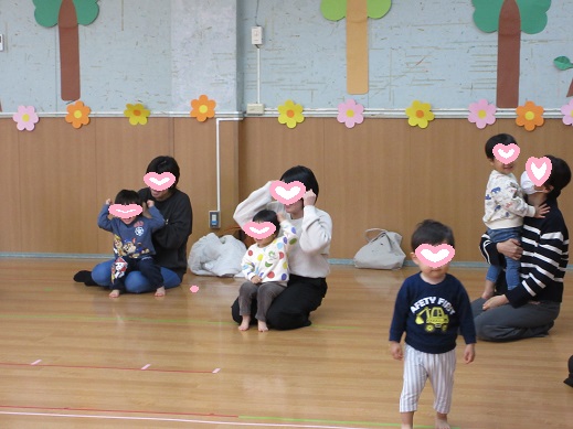 親子で手遊びを楽しむ1歳児