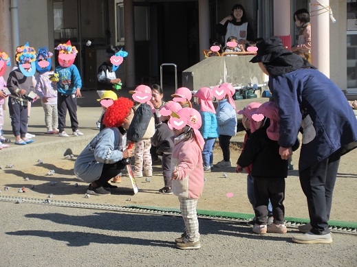 オニの手作りお面をつけて豆まきを楽しむ様子