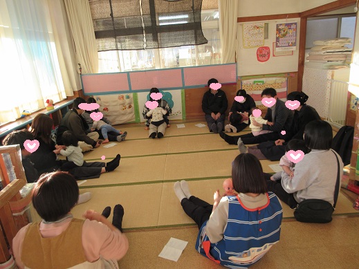 おうちの方の膝の上でわらべ歌を楽しむ0歳児