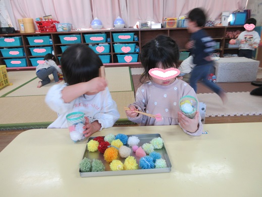 毛糸玉を箸でつかむ2歳児