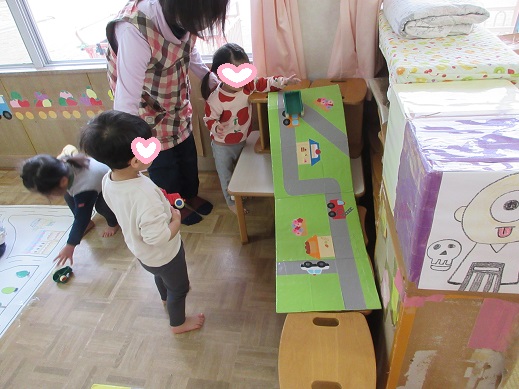 坂道に車を走らせるこどもたち