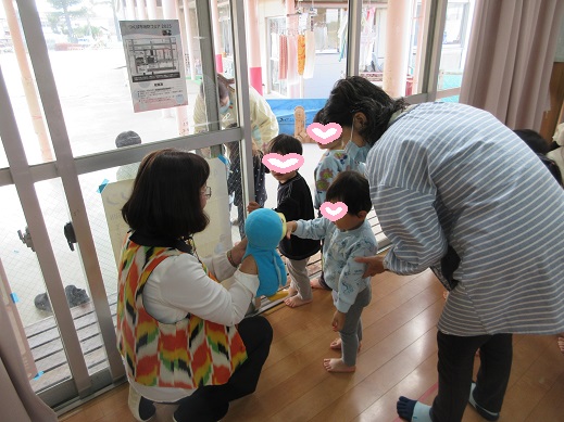 腹話術のパペットと握手する子どもたち