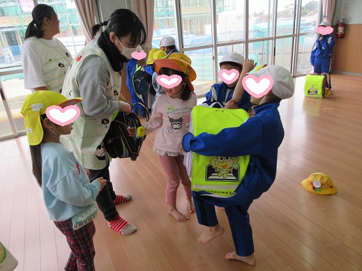 黄色い帽子とランドセルを背負わせてもらう様子