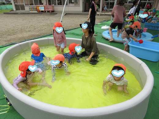 大きいプールで遊ぶ子どもたち
