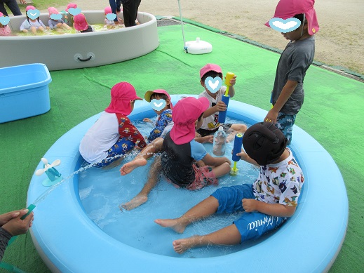 小さいプールで遊ぶ子どもたち