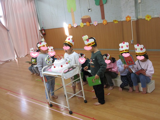 大きな誕生日ケーキのロウソクを吹き消そうとする誕生者