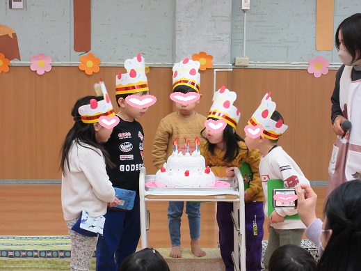 大きな誕生日ケーキのロウソクを吹き消そうとする様子