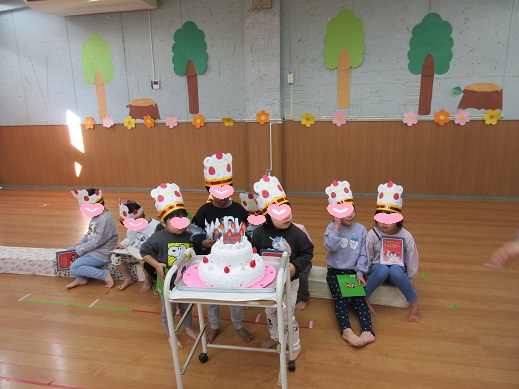 大きな誕生日ケーキを前に記念写真