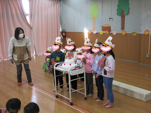 大きな誕生日ケーキを前に記念写真