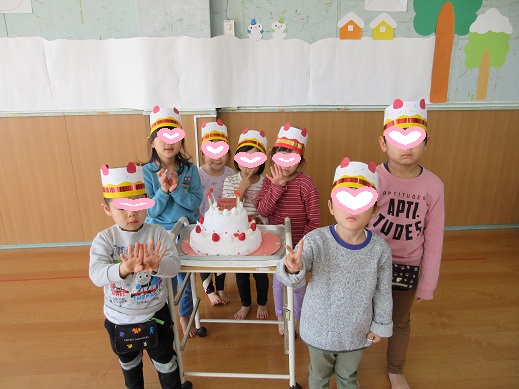 2月生まれの誕生者が、誕生日ケーキを前に記念写真を撮りました。
