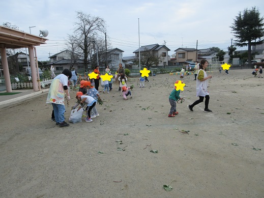 散らかった芋づるや葉っぱを掃除する子どもたち