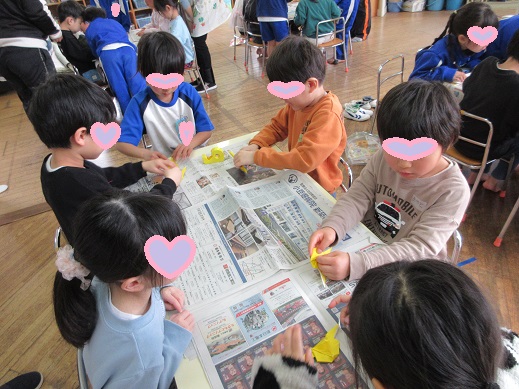 1年生に折り紙を教えてもらう場面