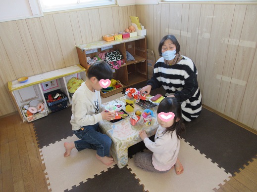 妖怪カフェで買った食べ物を所長先生や異年齢児が一緒に食べる様子