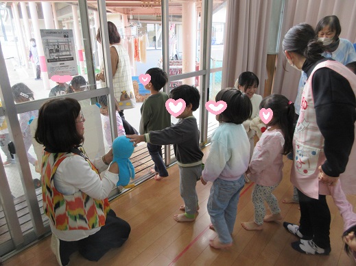 腹話術のパペットと握手する子どもたち