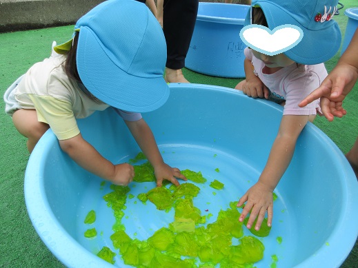 我先にと新しい色、黄色に触ろうと身を乗り出す子どもたち