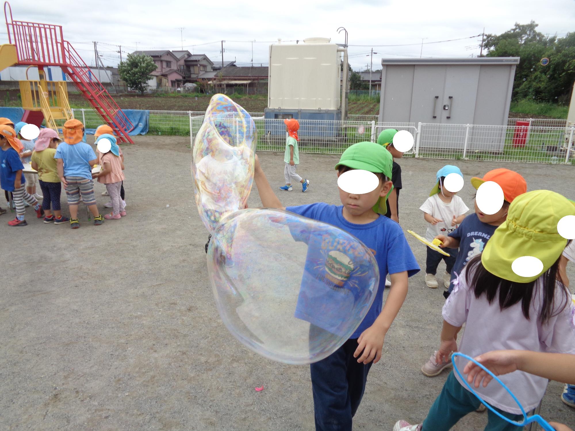 大きなシャボン玉作りに挑戦する子