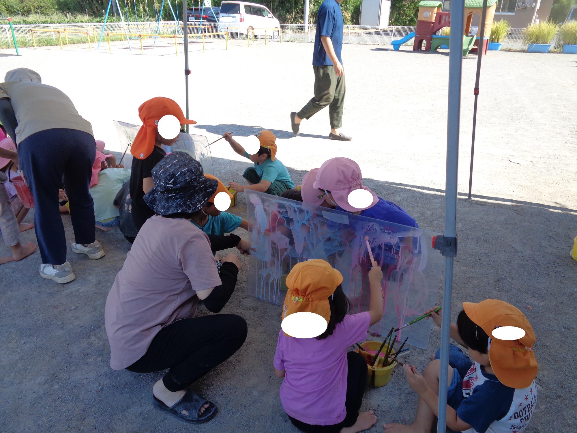 アクリル板に絵を描く子ども達