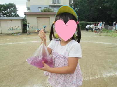 朝顔の花の色がついた水を持っています