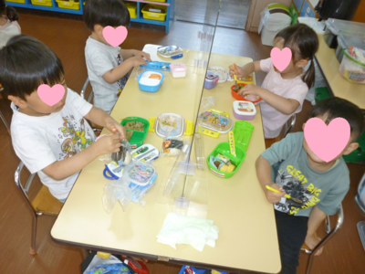 子どもたちがテーブルに座りお弁当を食べている写真