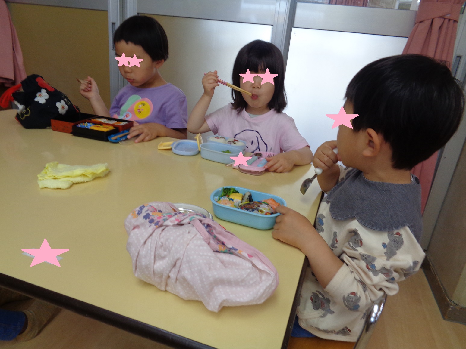 テーブルを囲みお弁当を食べる子どもたち