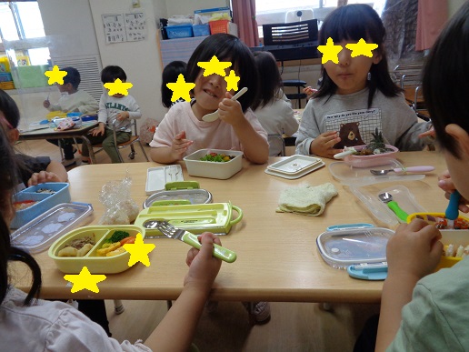 テーブルを囲みお弁当を食べる子どもたち