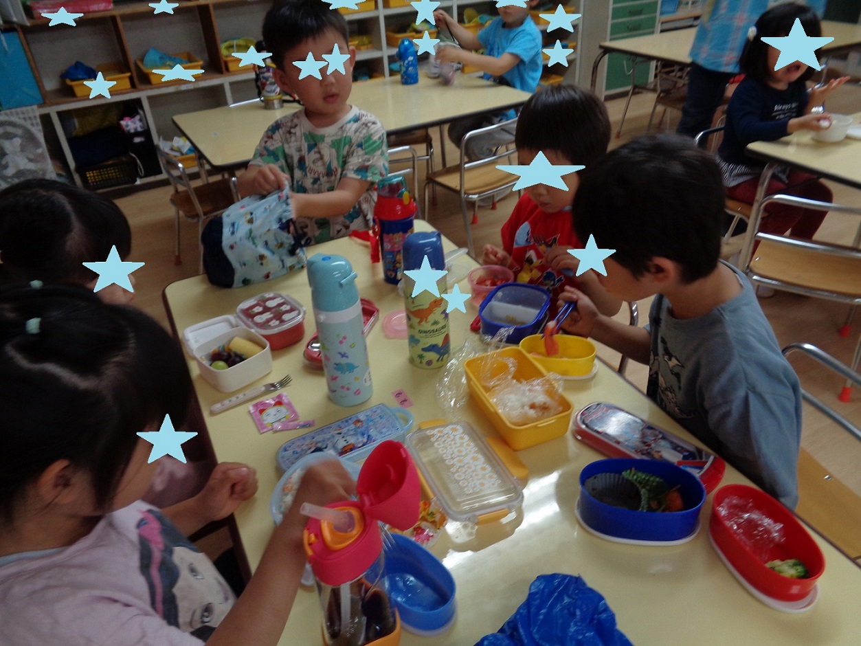テーブルの上にお弁当箱をいつか並べ食べる子どもたち