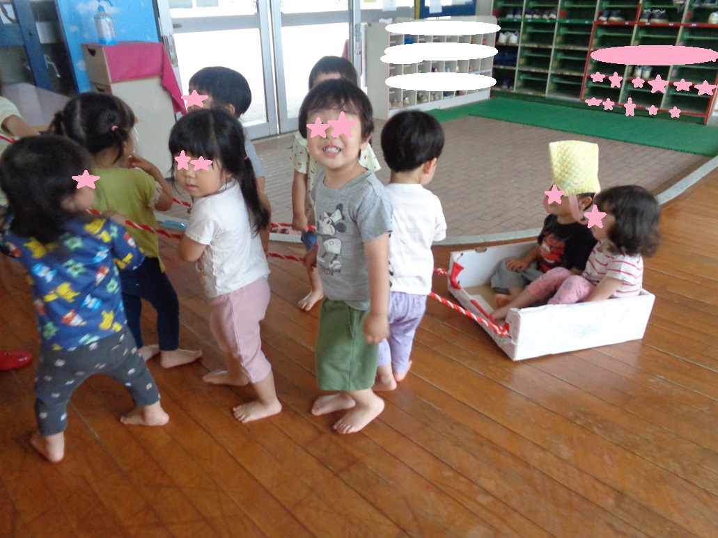 ひもを持ち歩いたり箱の中に座っている子どもたち