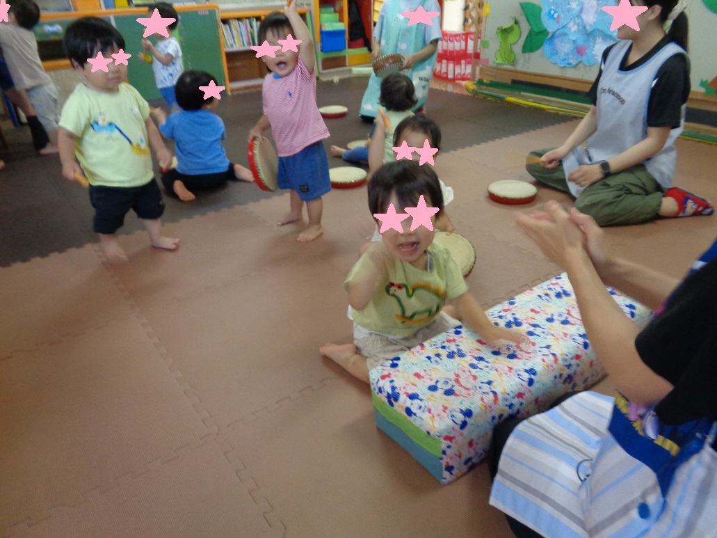 小さい子どもたちが手を上げたり座っている