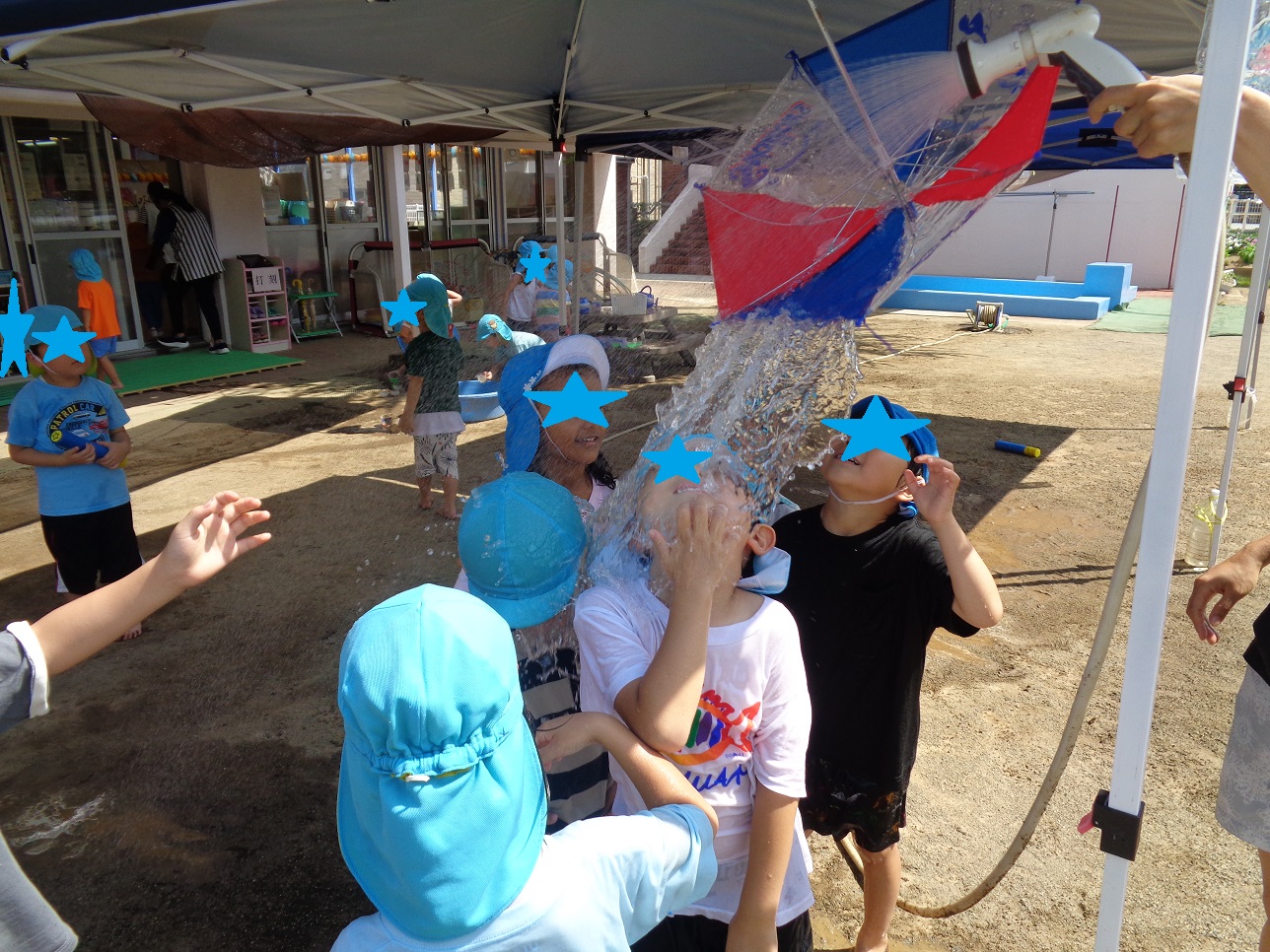 傘をタープテントにぶら下げて、その中に水をためるよ傾いて水がこぼれ、都の下に子どもたちが待ち構え上を見上げている。