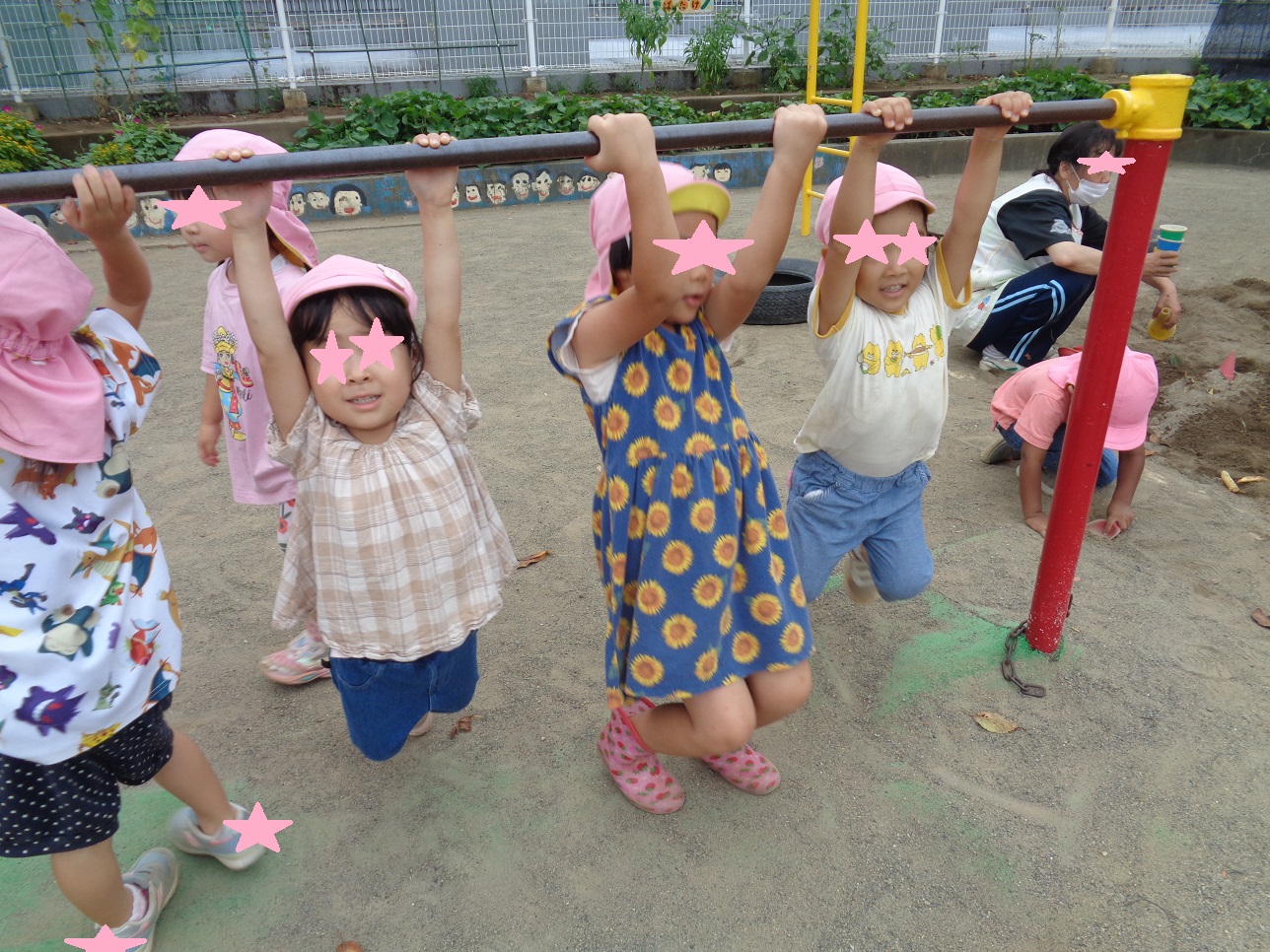 子どもたちが鉄棒をつかんでぶら下がっている