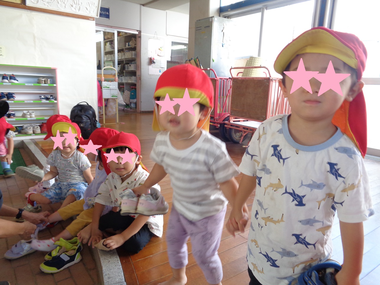 子どもたちが手をつないだり、座って靴を履かせてもらっている。