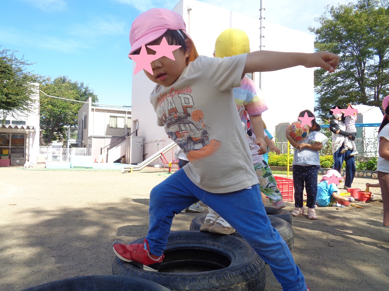 男の子がタイヤの上に両足を広げたっている