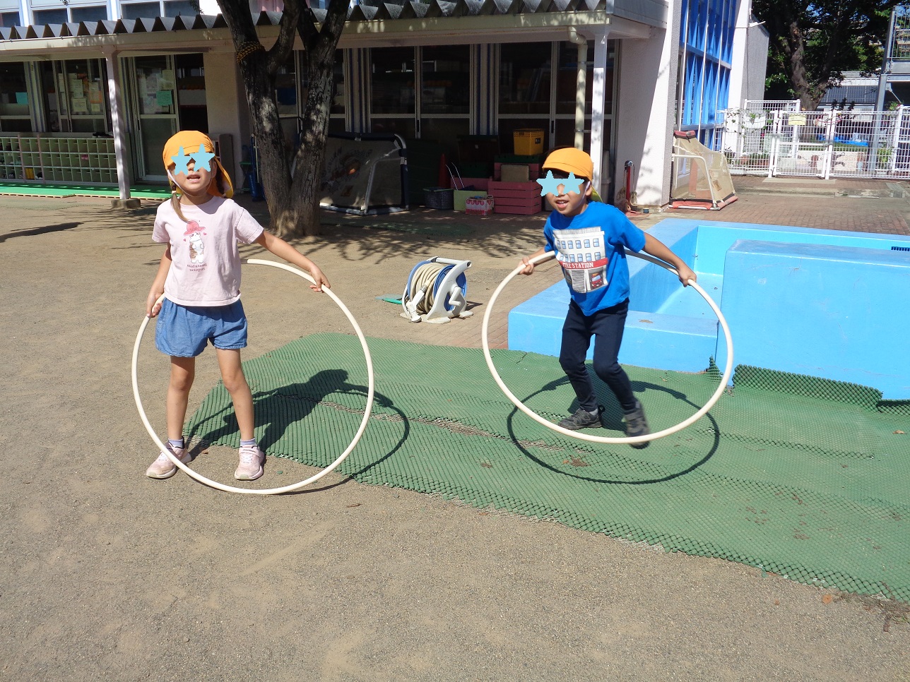 子どもが二人、体にフープを通して手で持っているところ