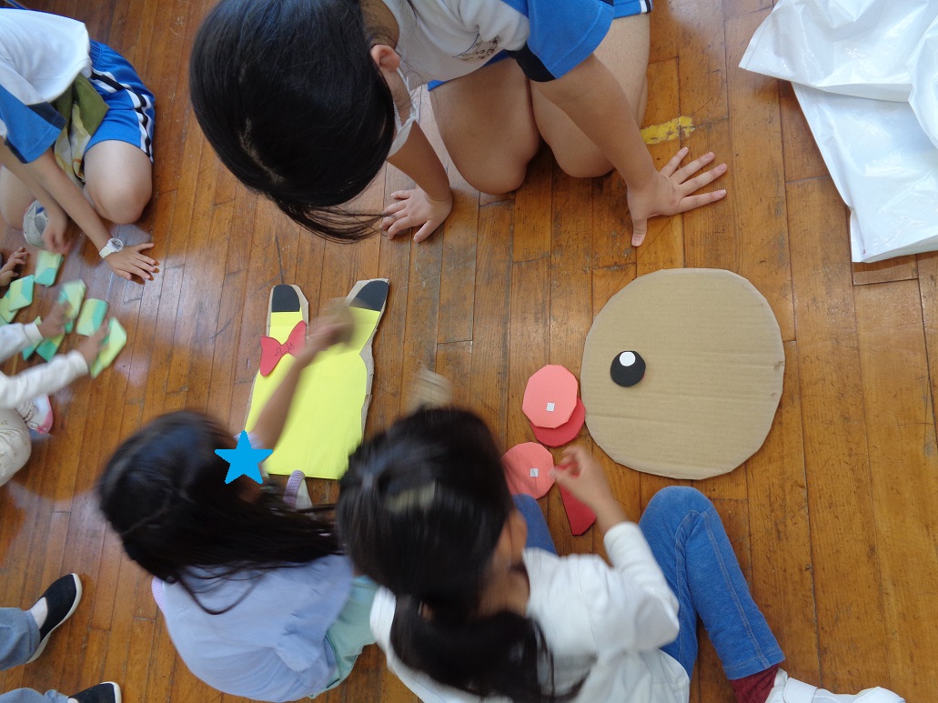 段ボールで作った顔に目や口を並べている。