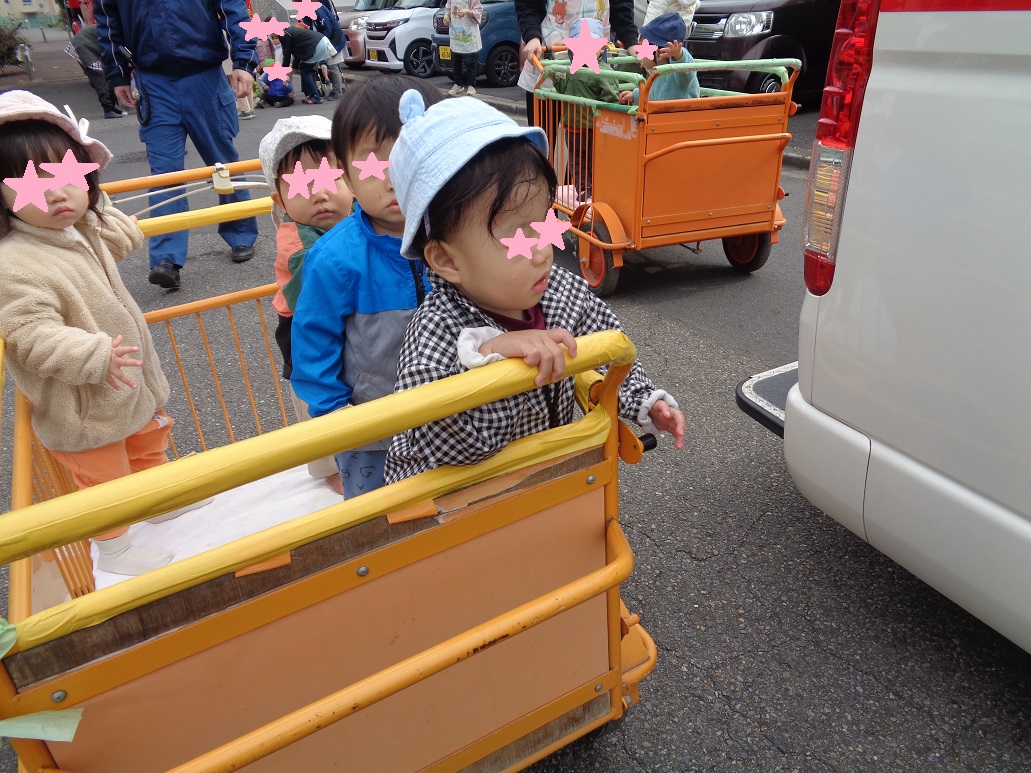 散歩者に乗った子どもが救急車を眺めている