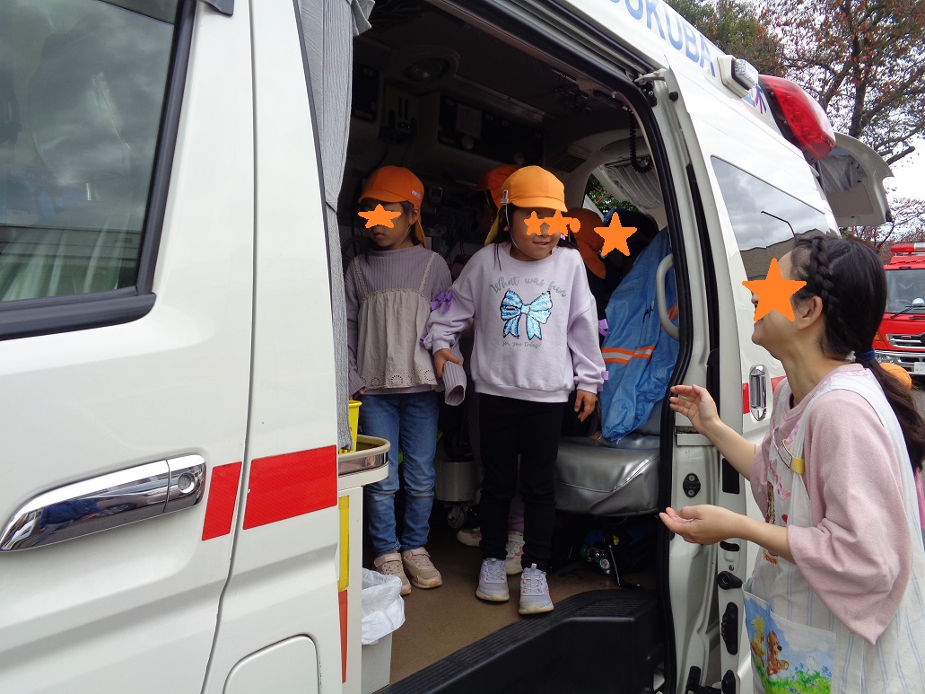 オレンジ色の帽子を被った子どもたちが救急車の中を見ている。