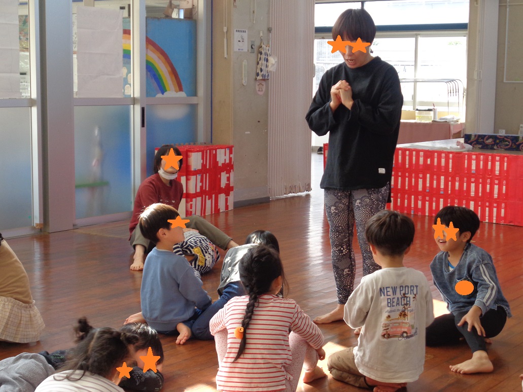 子どもたちが座ってヨガの先生の話を聞いている