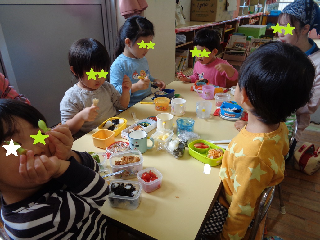 3歳の子どもがフォークやスプーンを使ってお弁当を食べている