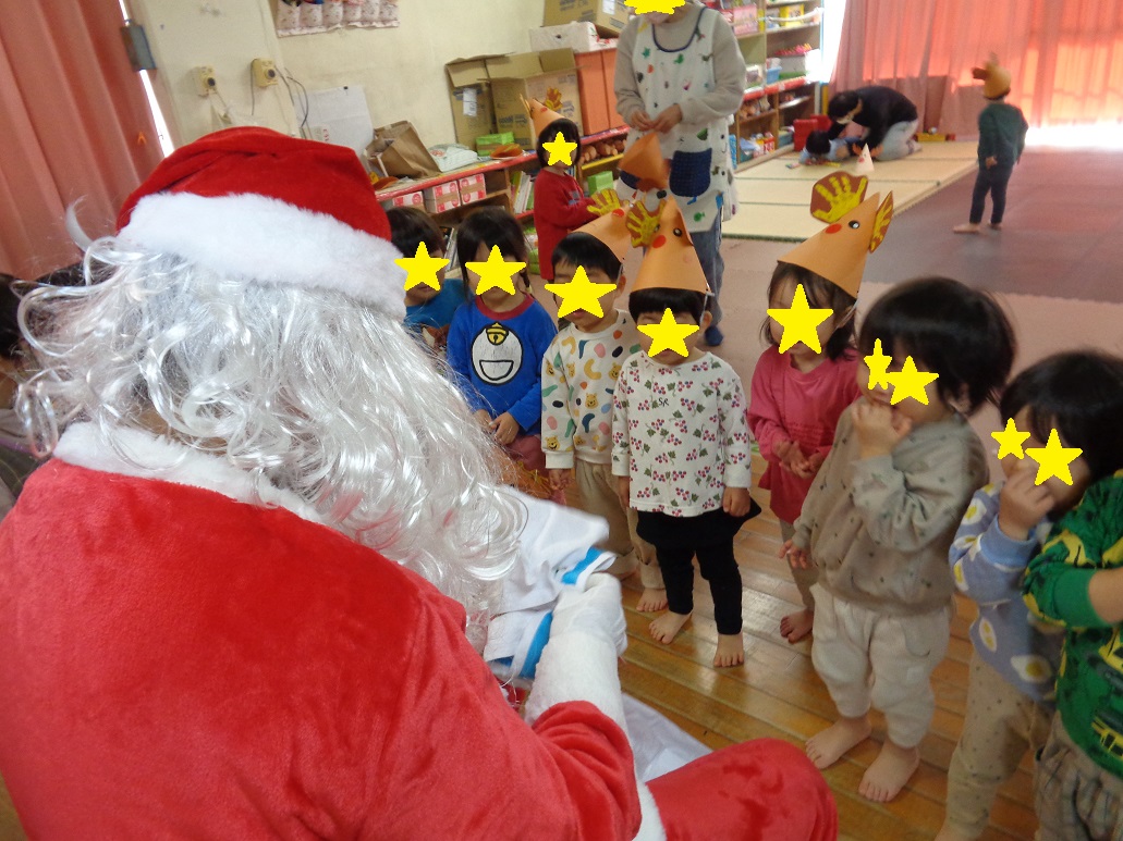 子どもたちがサンタクロースからプレゼントをもらおうと待っている